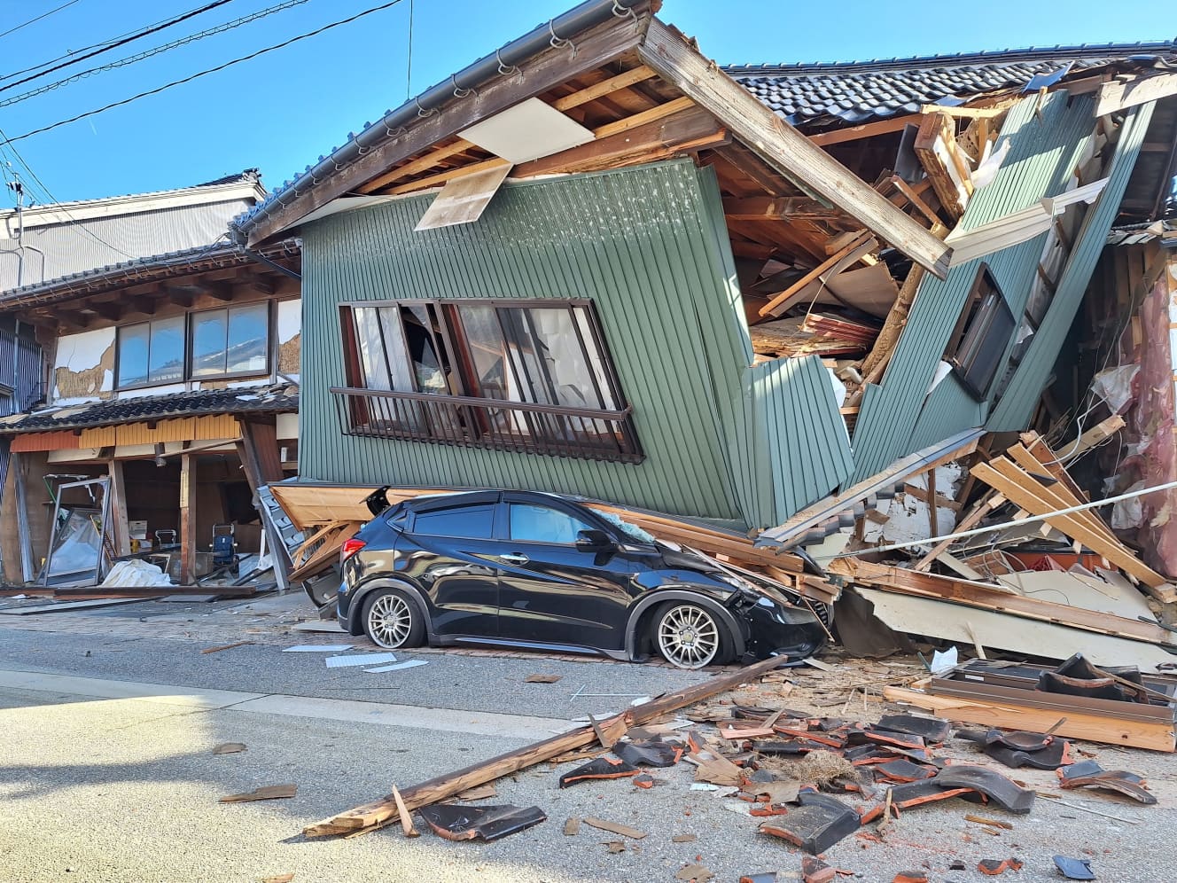 倒壊した家屋に押しつぶされた車。石川県七尾市内で。１月２日撮影