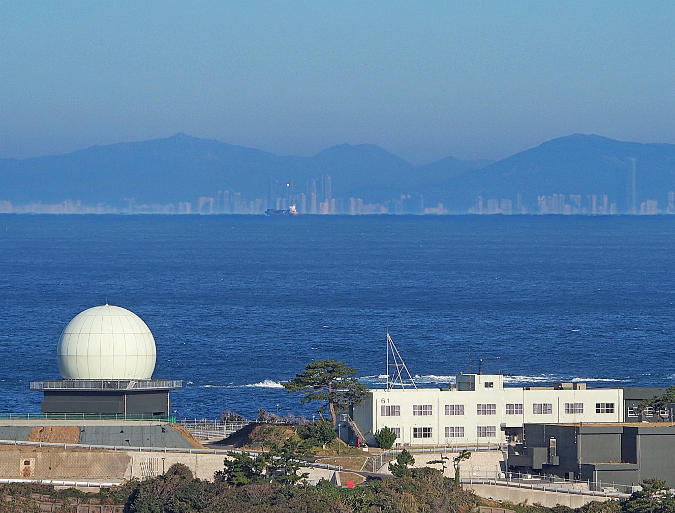 対馬島の北端からは、島から１㎞の地点にある海栗島（うにじま）の自衛隊レーダー越しに、釜山の街並みがうっすらと見える