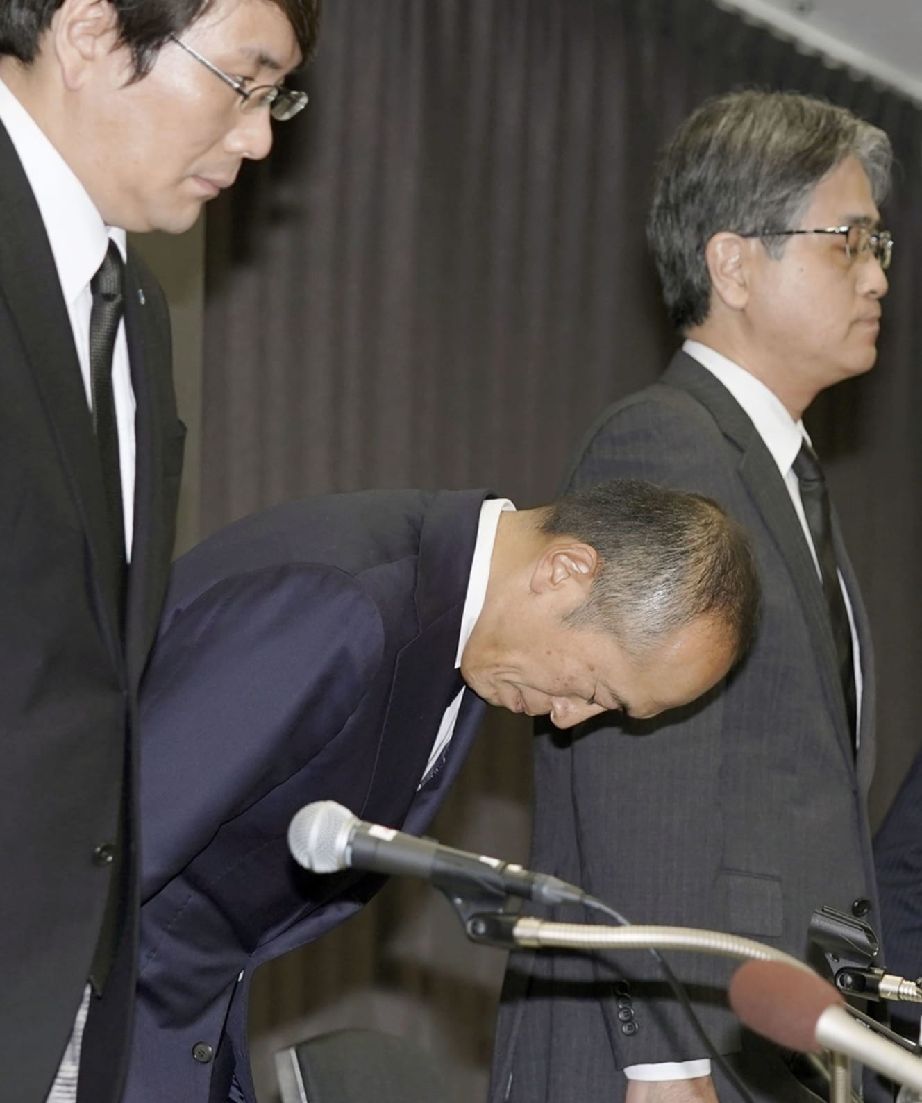 ３月29日、大阪市内で開かれた記者会見で謝罪する小林製薬の小林章浩社長（中央）ら幹部社員