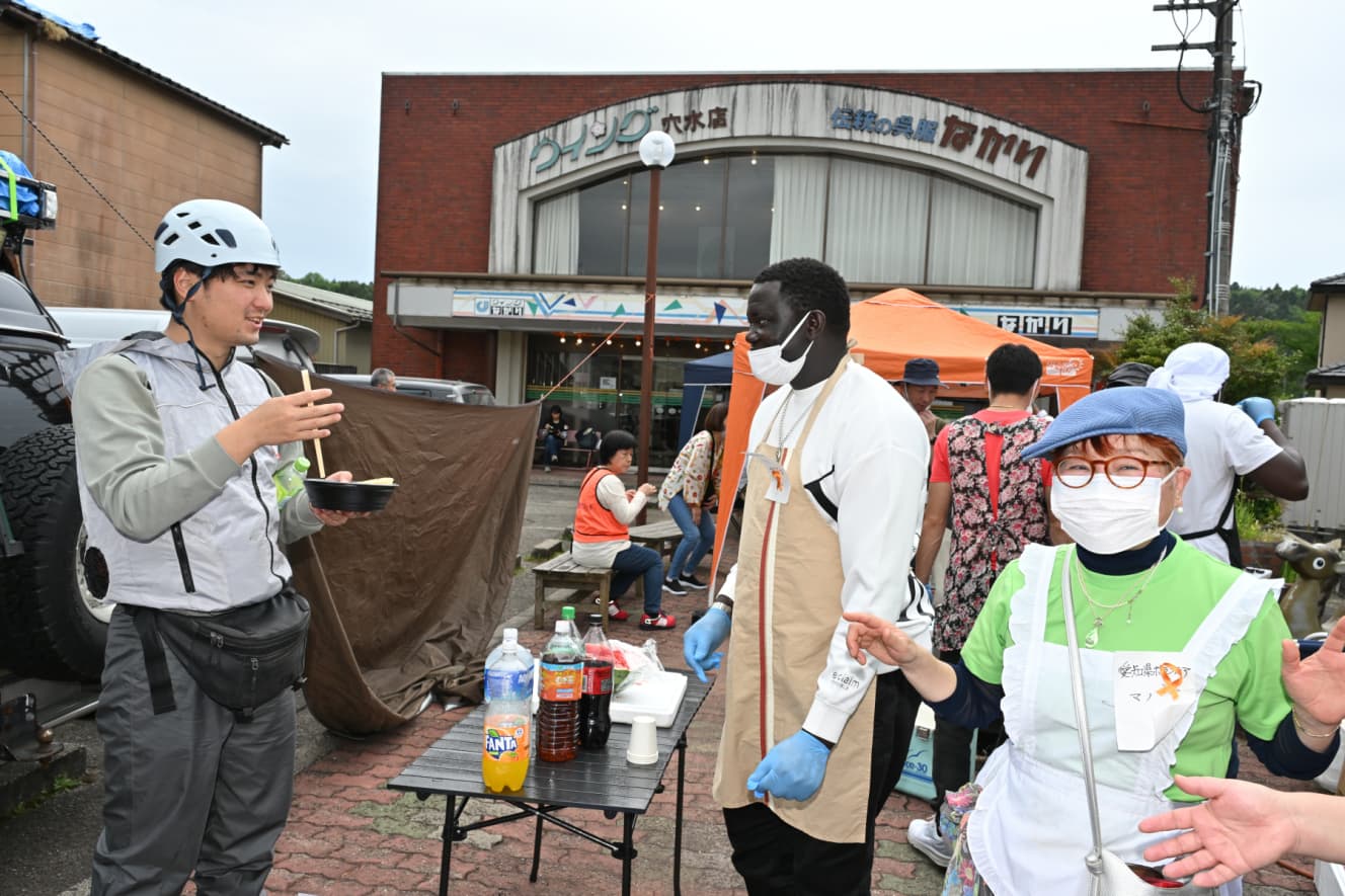 料理を振る舞う外国人ボランティアたち。味は好評だ