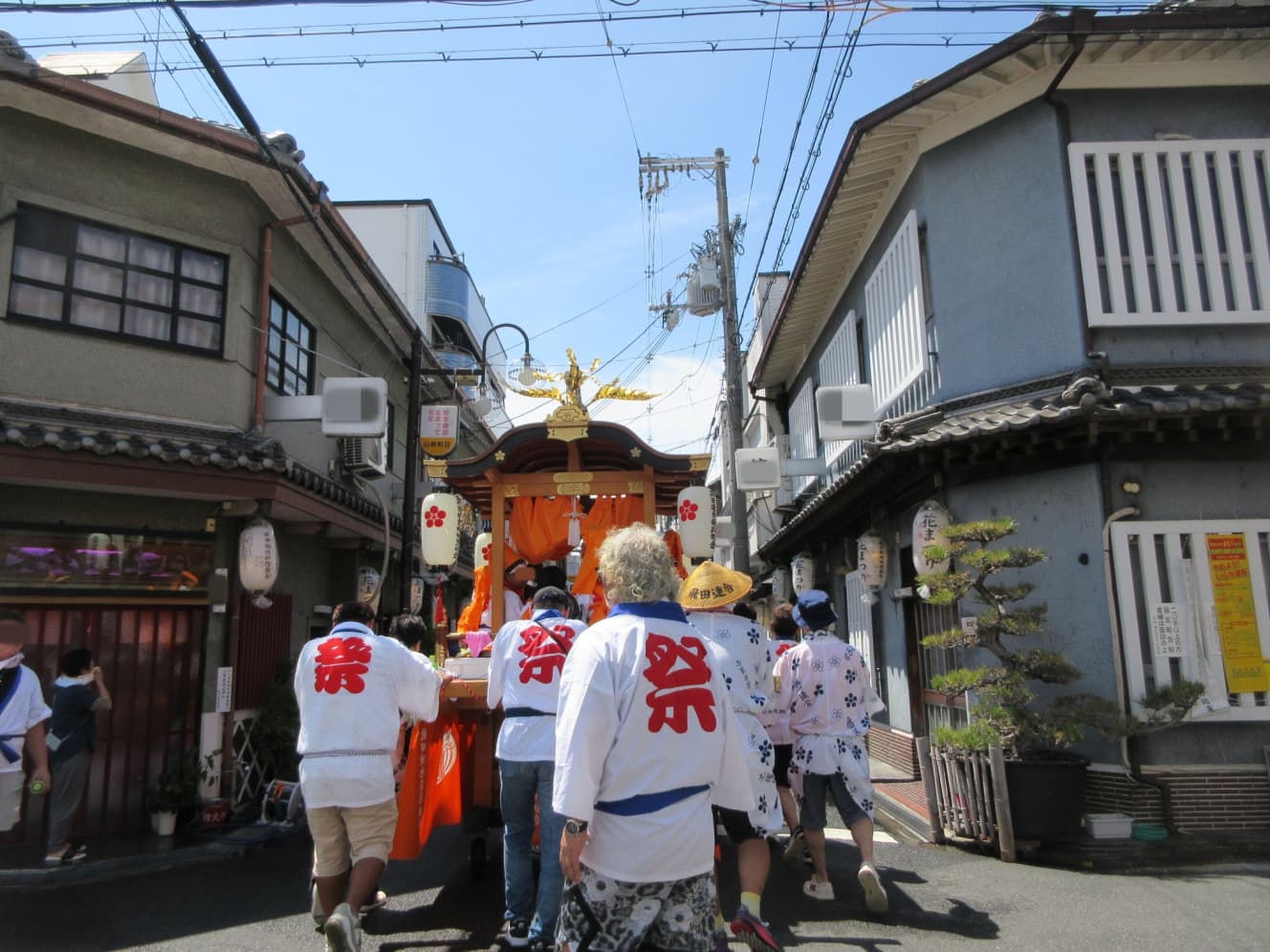 休憩を終え、再びだんじりがメイン通りを進む。料亭のおばちゃんも女性も興味津々で眺めていた