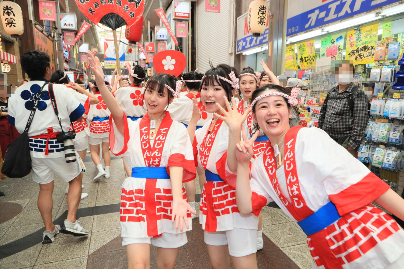 神輿の前を練り歩く彼女らも元気良く周囲の店舗や通りがかった人たちにアピールしていた