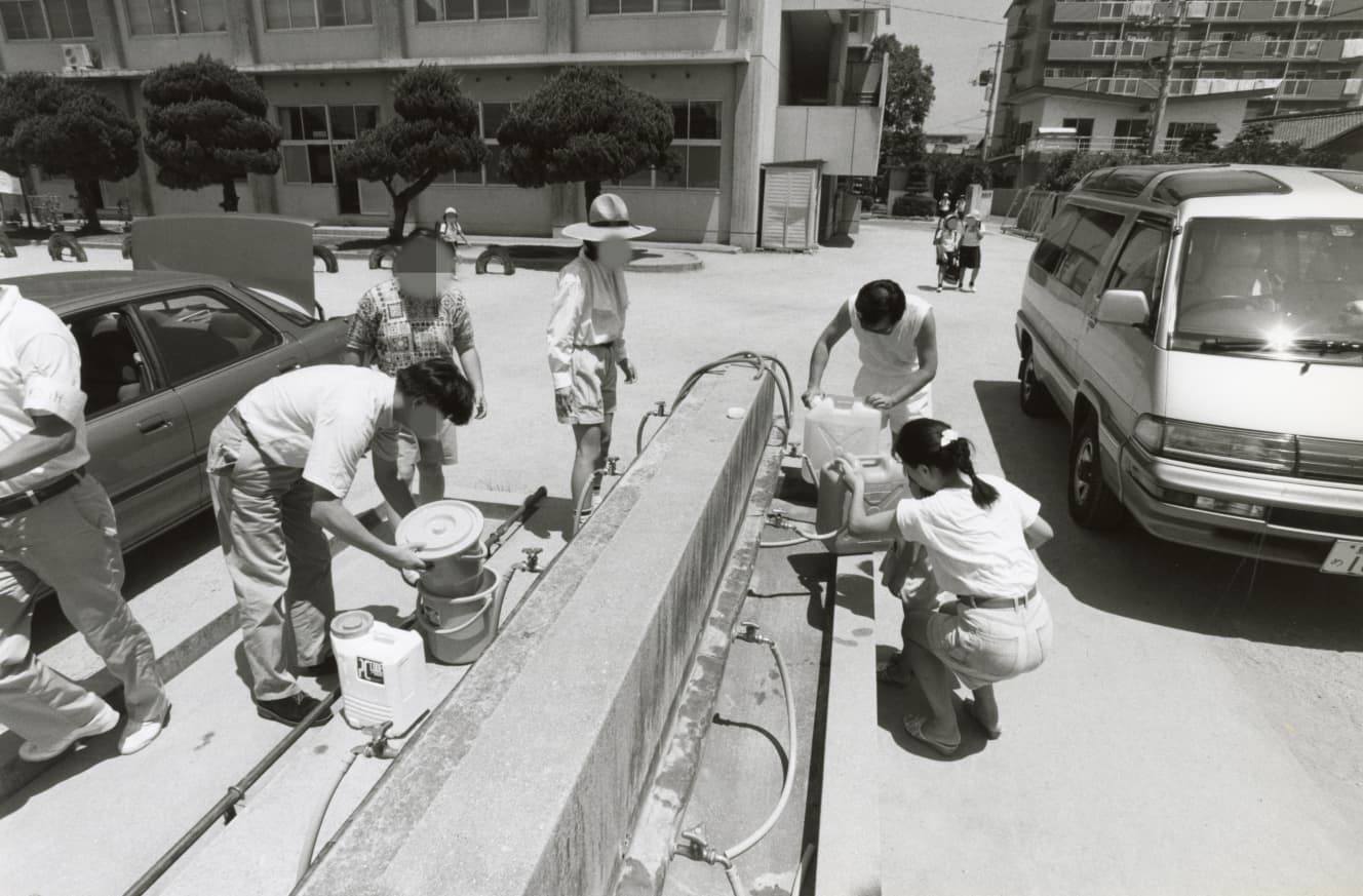 高松市内の小学校37ヵ所に設けられた給水所に水を汲みにくる市民（’94年８月５日号）