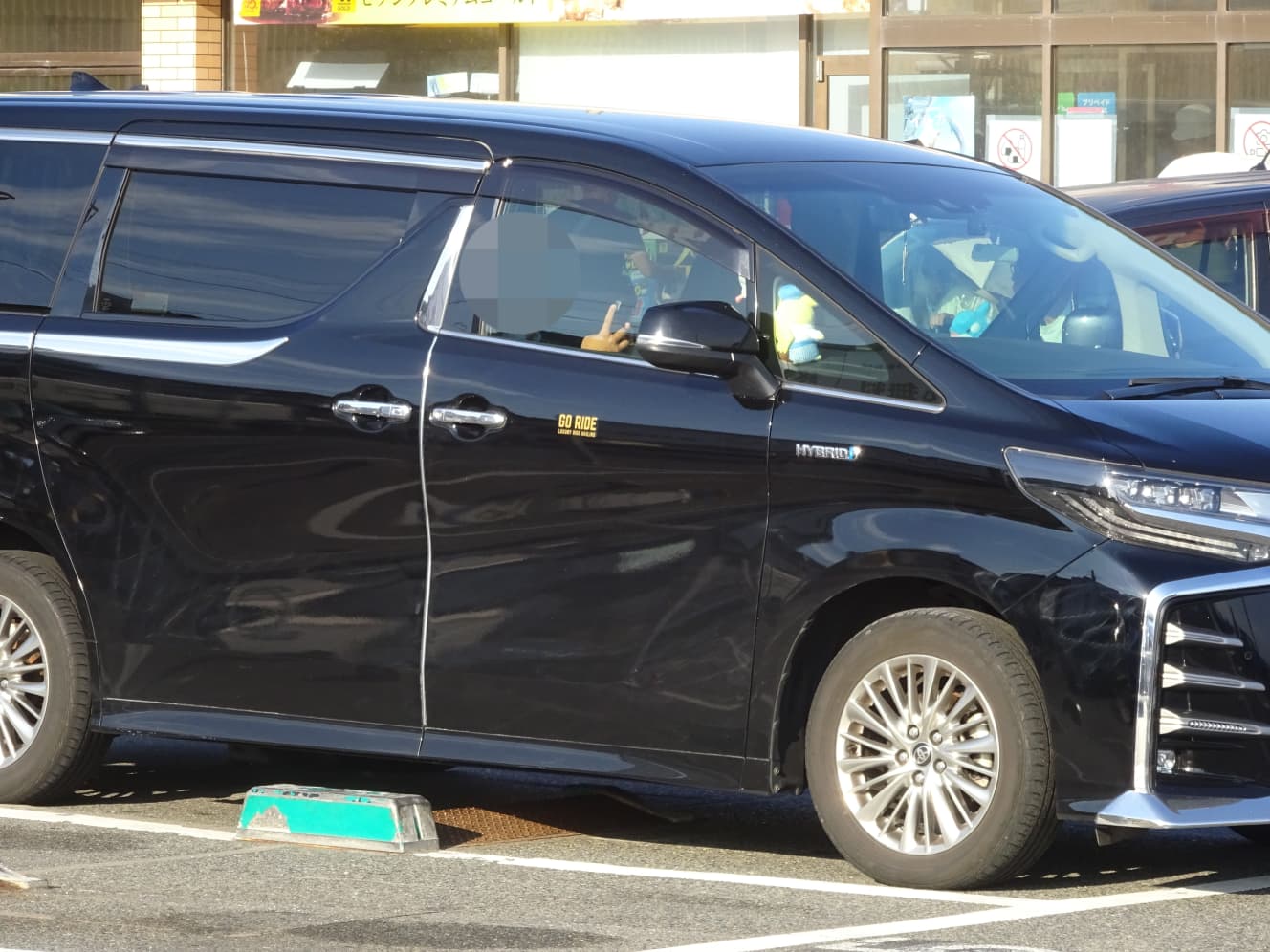 運転席で待機する“白タク”の運転手。ロック板（料金未払いの際に車両を固定する板）は下がったままだ