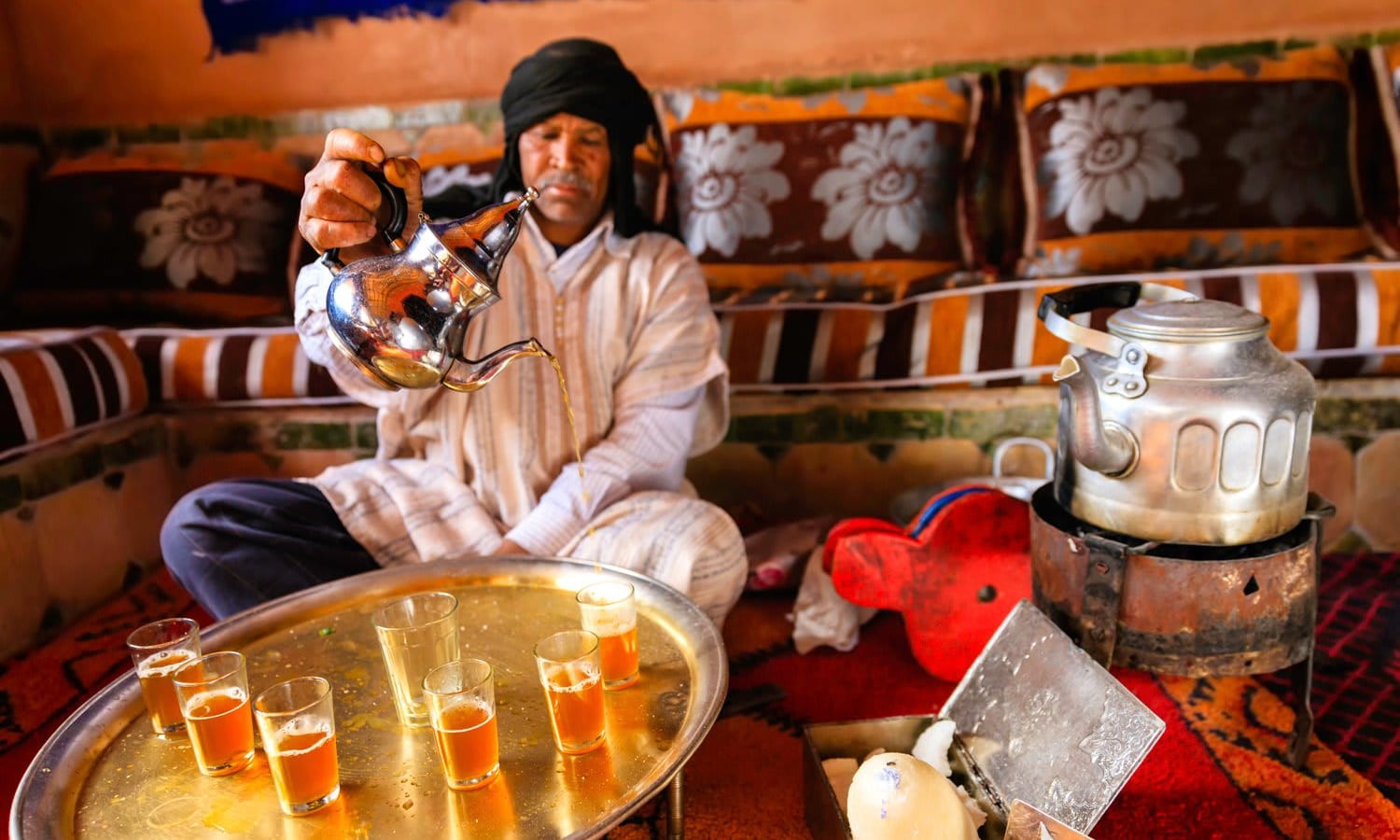 Moroccan man preparing Maghrebi mint tea