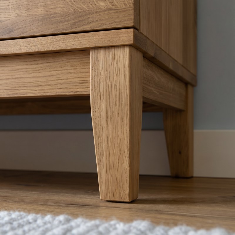 ahaufnahme eines konischen Beins aus Massivholz am Sideboard-Korpus, leicht schräg