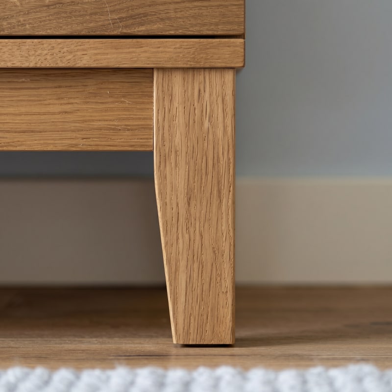 ahaufnahme eines konischen Beins aus Massivholz am Sideboard-Korpus, frontal