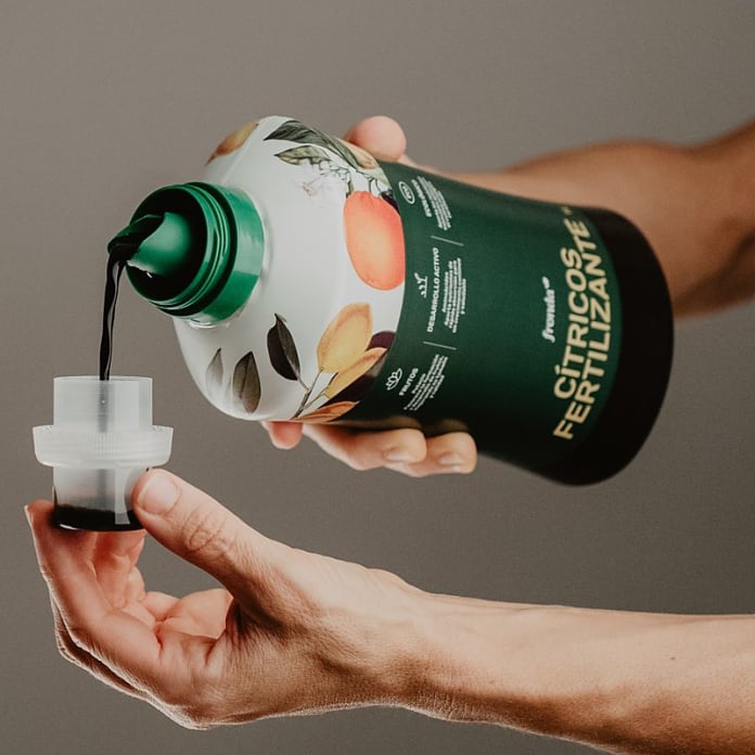 Manos dosificando fertilizante líquido de marca Fronda