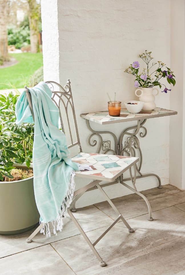 Silla con manta junto a planta
