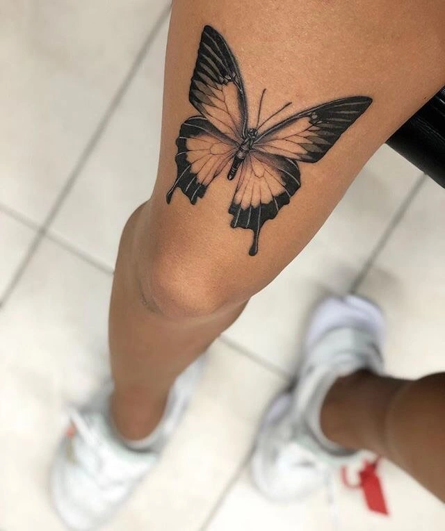 Tiny red butterfly tattooed on the hip