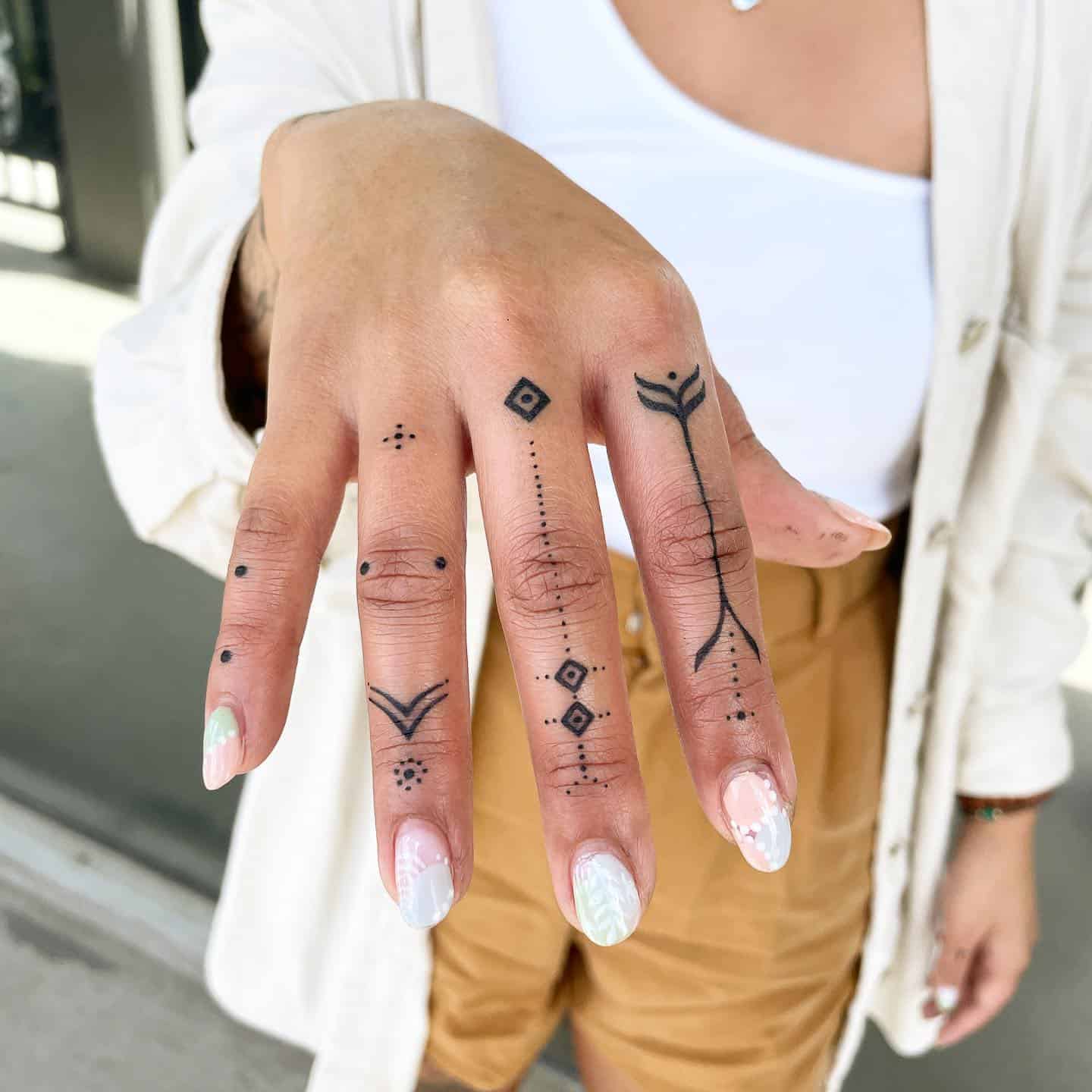 Minimalist lotus flower tattoo on finger