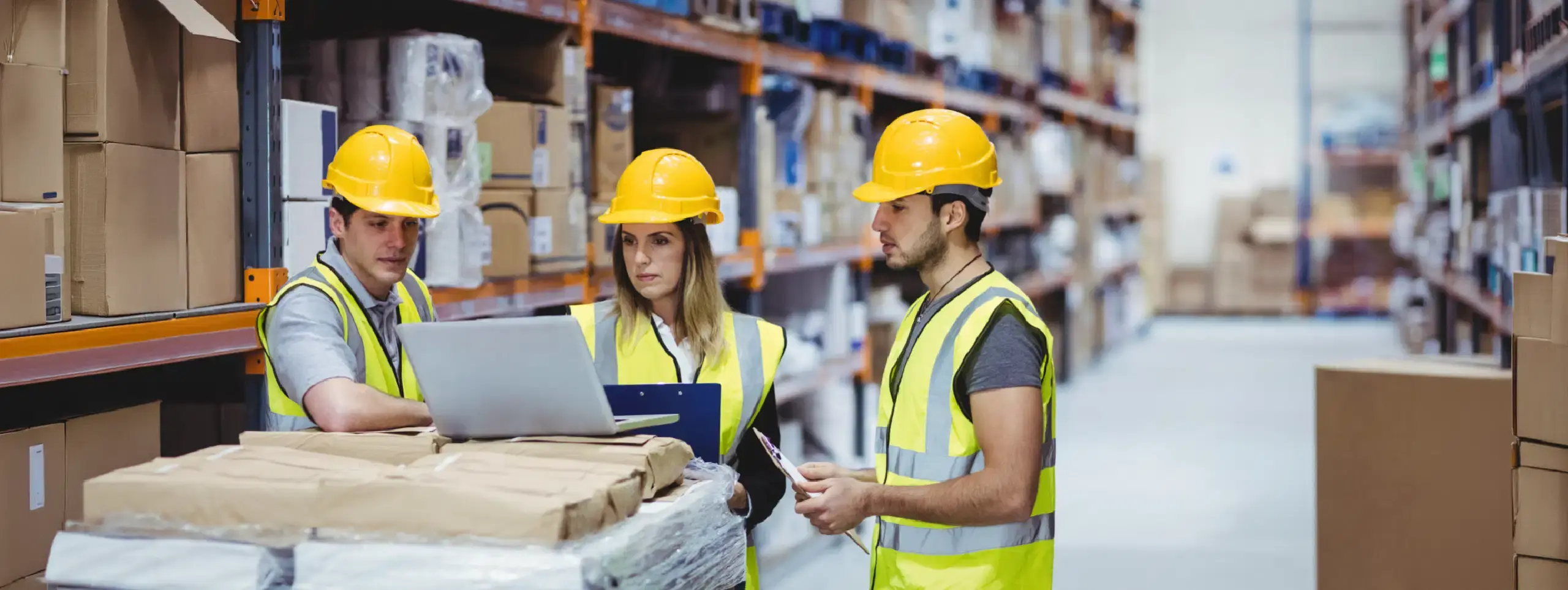Warehouse staff reviewing multi-location inventory data inside a fulfillment center