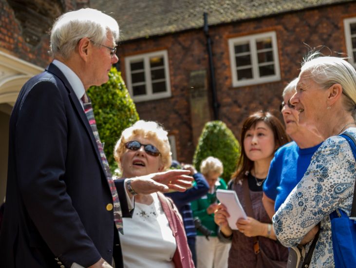 tour guide talks to attendees in the tudor courtyard