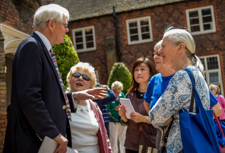 tour guide talks to attendees in the tudor courtyard