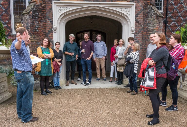 Group of people listening to tour guide in the tudor courtyard
