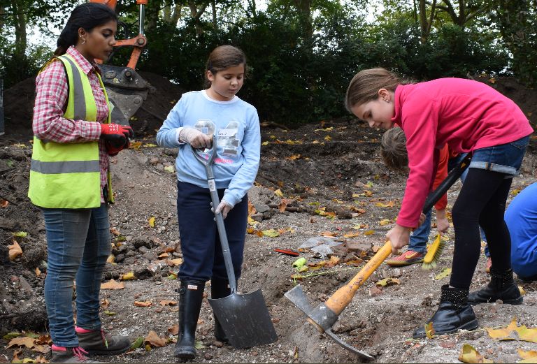 three girls help with an archaeology dig