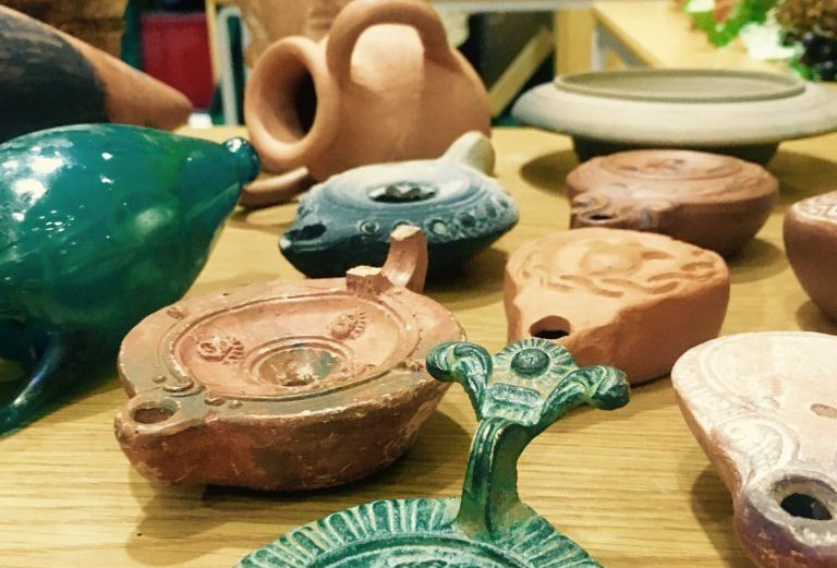 a number of old clay and metal oil lamps are on a table