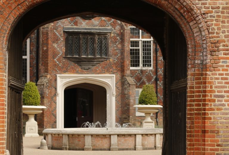 red brick tudor courtyard seen through the front entrance archway