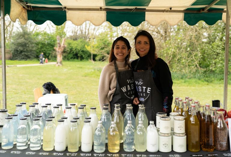 Image shows two people standing behind a stall