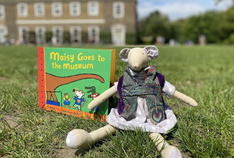 Image shows a mouse toy and book on the Palace's lawn.