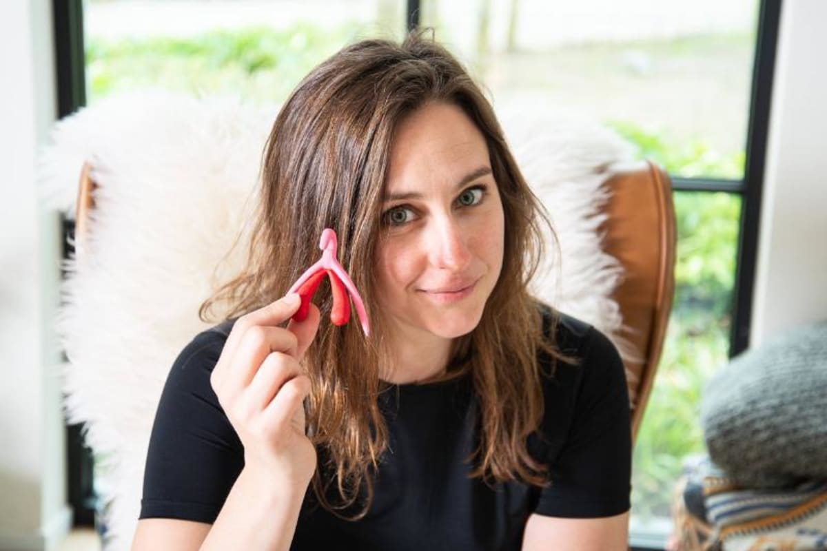 Griet Alice toont een 3D-geprint anatomisch model van een clitoris.