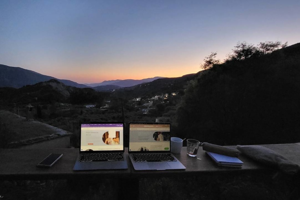 Het mooiste kantoor van de wereld - een fantastisch uitzicht over een vallei in de Sierra Nevada. Twee laptops op de voorgrond.