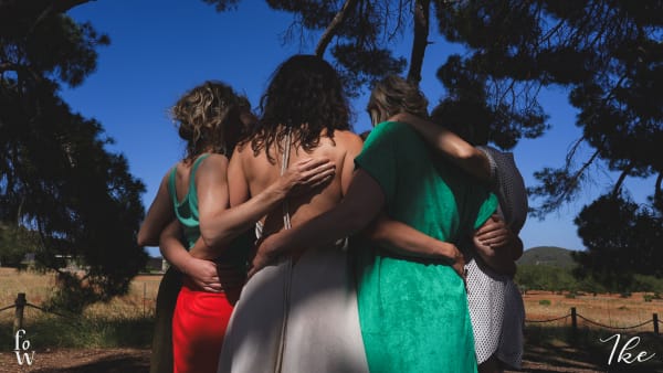 Een groep vrouwen op het Yoni Retreat in een cirkel; de foto is genomen vanop de rug.