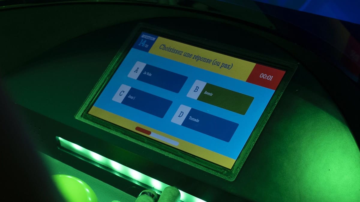Cabine Blindtest musical à Saint-Denis : écran tactile bleu-vert et boutons lumineux dans la salle de jeu équipée, La Réunion