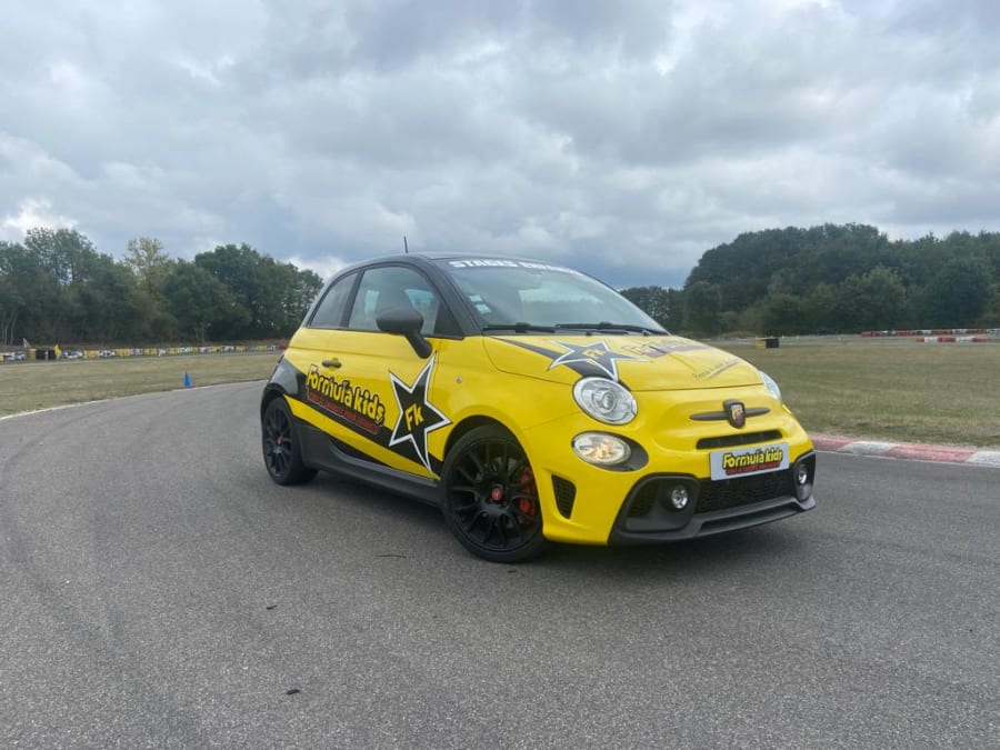photo d'une fiat 500 jaune en train de rouler sur un circuit