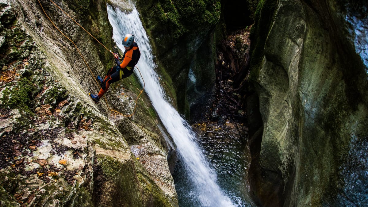 Homme qui descend d'une falaise en rappel