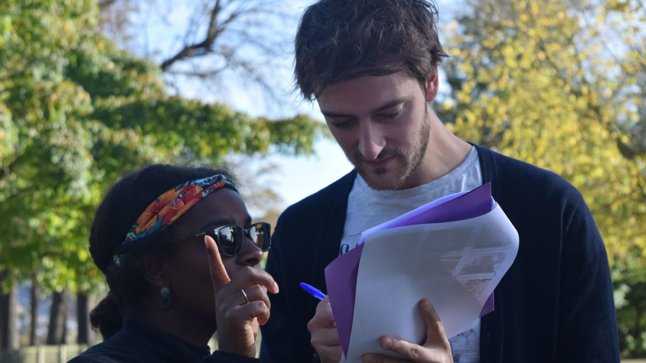 un homme et une femme discutant avec une feuille de papier à la main