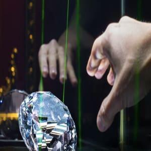 main tentant de récupérer un diamant protégé par des détecteurs laser