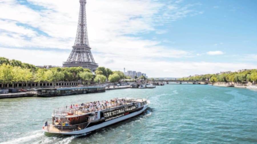 une péniche navigant sur la seine avec la tour eiffel en fond