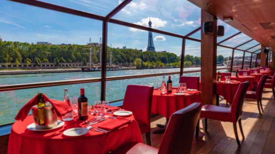 table avec nappe rouge d'une péniche navigant sur la seine près de la Tour Eiffel