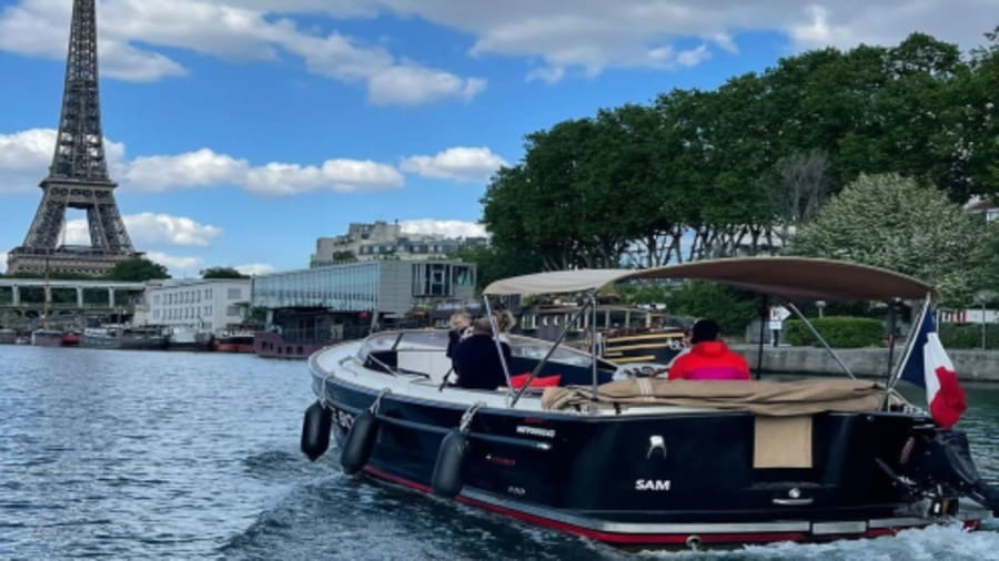 photo d'un bateau à la coque noire navigant sur la seine