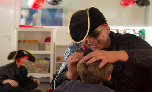 Animateur déguisé en pirate maquillant un enfant