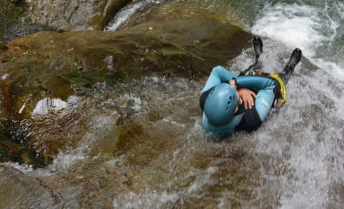 personne glissant dans un toboggan les bras croisés