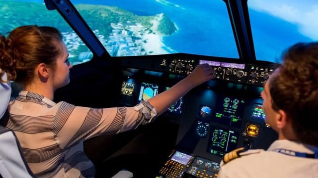 Fille qui pilote un simulateur avion de ligne