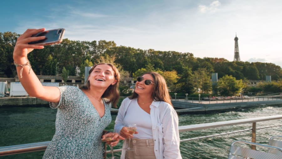 Deux jeunes femmes avec une tenue d'été entrain de faire un selfie sur une péniche navigante à paris