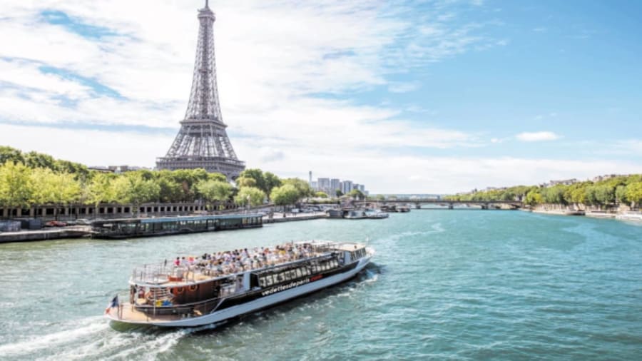 une péniche navigant sur la seine avec la tour eiffel en fond