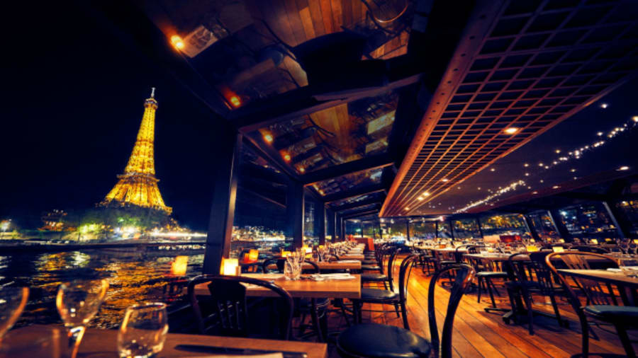 L'intérieur d'un bateau diner croisiere avec la tour eiffel sur le coté