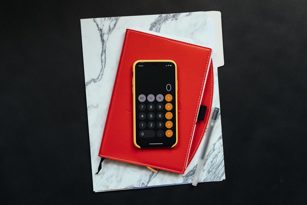 An image of a calculator and a file folder, representing the act of budgeting for a funeral and funeral comparison options of the website Funeralocity