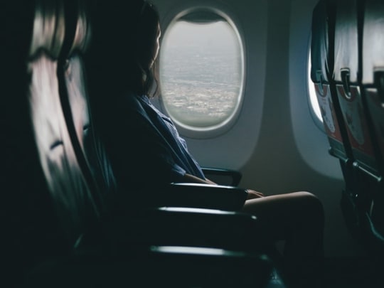 A person sitting in the window seat of an airplane