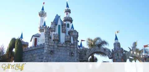 Image description: This is a photo of a fairytale-like castle under a clear sky. The castle features multiple tall spires with blue rooftops and flags atop them. There is a central portion with a clock and windows that resemble a classic medieval European castle. Decorative stonework adorns the facade, and turret towers are positioned on either side, connected by a stone wall with arched walkways underneath. Below the castle, the word "GiftsOf" is superimposed on the image.

At FunEx.com, we're dedicated to ensuring you experience the magic for less—shop with us to find the best savings and lowest prices on tickets to your favorite storybook destinations.