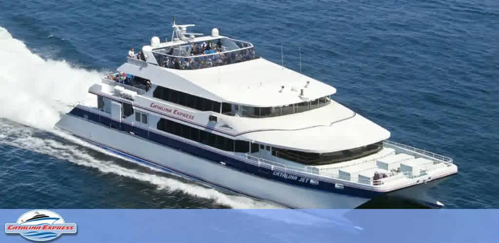 This image features a sleek, white and blue high-speed ferry named Catalina Express, racing across a serene expanse of blue ocean. The vessel has multi-tiered decks with passengers visible on the upper deck, enjoying the sunshine and sea breeze. The boat leaves a foamy white wake behind as it moves swiftly through the water. The Catalina Express logo is visible on the side of the boat and on the bow. FunEx.com offers exclusive discounts on tickets, ensuring you can embark on your maritime adventure at the lowest prices.