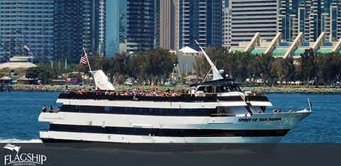 This image showcases a large, multi-deck cruise boat adorned with the "Flagship" logo, sailing across calm waters with a clear view of a city skyline in the background. The upper deck is bustling with passengers enjoying the open air and panoramic views, while the American flag waves proudly at the rear of the boat. The urban backdrop features a row of modern, high-rise buildings, contributing to a vibrant waterfront setting.

At FunEx.com, we're committed to providing our customers with unbeatable savings – check out our site for the lowest prices on tickets to your next maritime adventure!