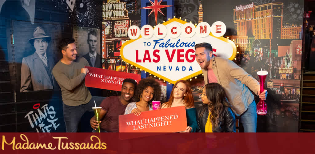 Image Description: The photo showcases a vibrant and lively group of five individuals posing for a picture at Madame Tussauds in Las Vegas, Nevada. In the foreground, a smiling man stands to the left, appearing to interact with a wax figure that resembles a classic film noir detective. Center stage, a couple joyfully lounges against a red barrier sporting playful phrases hinting at the well-known Las Vegas slogan, "What happens here, stays here." The woman holds a green slushy drink, and both radiate happiness. To the right, another pair, with broad smiles, seem to be sharing a joke; one of them is holding an oversized red souvenir drink. Behind the group, a backdrop featuring iconic Las Vegas images and signs enhances the atmosphere of the scene. Bright, prominent text welcomes visitors to 'Fabulous Las Vegas Nevada,' enhancing the celebratory mood.

Embark on an unforgettable adventure at Madame Tussauds, and don't forget to check out FunEx.com for the lowest prices on tickets, ensuring you can enjoy the greatest savings without compromising on the fun!