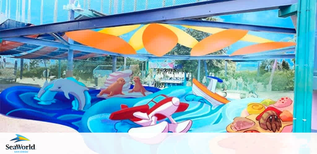 Image of a colorful water play area under a shaded structure at SeaWorld San Diego. It features a bright blue pool with dolphin-shaped watercraft, red and white striped boats, and people enjoying the water. Vividly colored floating canopies add to the festive atmosphere.