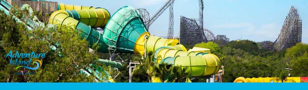 Water slides at Adventure Island with roller coaster in the backdrop.