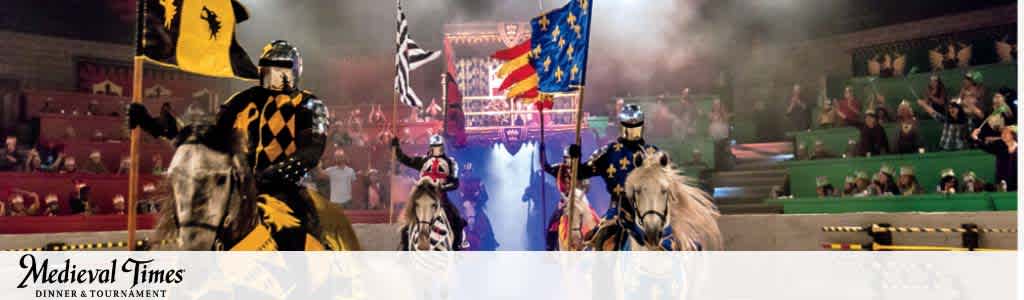 Knights on horseback in Medieval Times arena with cheering crowd.